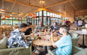 Familie nyder pizza sammen inde i en moderne restaurant på Camping de Paris, Île de France, Frankrig.