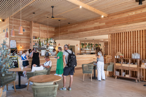 Personas disfrutan de una cafetería moderna de madera en Camping de Paris, Île de France, Francia.