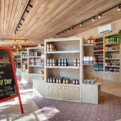 Supermercado en Camping de Paris, Île de France, con estanterías de madera y cartel de pizarra.