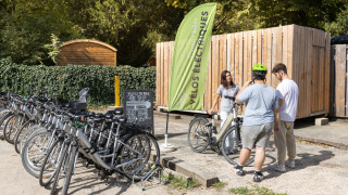 Huéspedes alquilan bicicletas eléctricas en Camping de Paris, parque vacacional en Île de France.