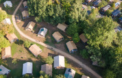 Luftfoto af telte og hytter omgivet af træer på Camping de Strasbourg, feriepark i Grand Est, Frankrig.