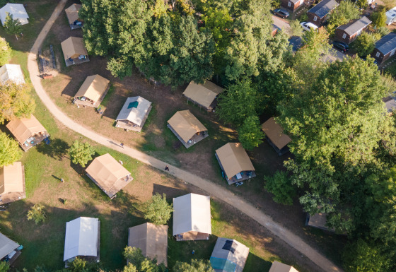 Luchtfoto van tenten en hutten tussen bomen op Camping de Strasbourg, vakantiepark in Grand Est, Frankrijk.