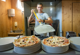 Een pizzabakker bereidt pizza’s in de keuken van Camping de Strasbourg, Grand Est, Frankrijk.