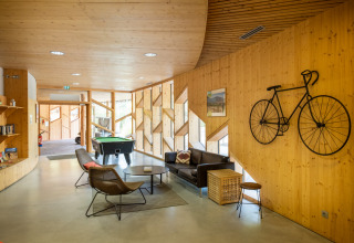 Modern lounge area at Camping de Strasbourg in Grand Est, France, featuring bicycle wall art and seating.