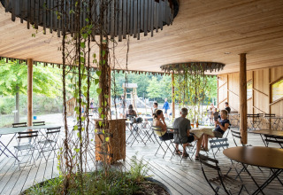 Buitenruimte met houten vloer en planten bij Camping de Strasbourg vakantiepark, Grand Est, Frankrijk.