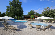Udendørs swimmingpool og liggestole under parasoller ved Camping de l'Ill - Colmar, en feriepark i Grand Est, Frankrig.