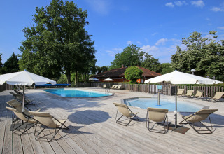Buitenzwembad met ligstoelen en parasols bij Camping de l'Ill - Colmar, een vakantiepark in Grand Est, Frankrijk.