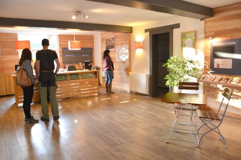 Reception al Camping de l'Ill - Colmar con ospiti, banco informazioni e depliant in Grand Est, Francia.