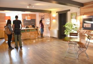 Reception al Camping de l'Ill - Colmar con ospiti, banco informazioni e depliant in Grand Est, Francia.