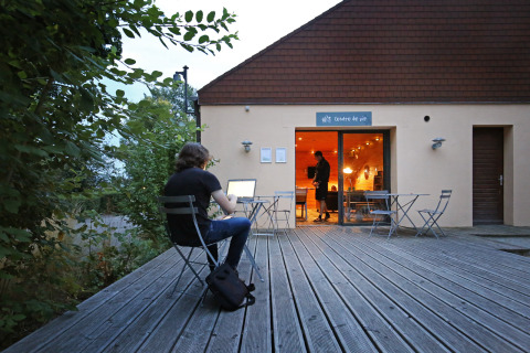 Persoon werkt buiten op een laptop bij Camping de l’Ill - Colmar, een vakantiepark in Grand Est, Frankrijk.