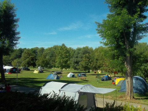 Tiendas de campaña en un campo verde del Camping de l'Ill - Colmar, parque vacacional en Grand Est, Francia.
