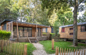 Udendørsbillede af Chalet Evasion-hytte og campingvogn omgivet af grønne træer i Camping de Paris.