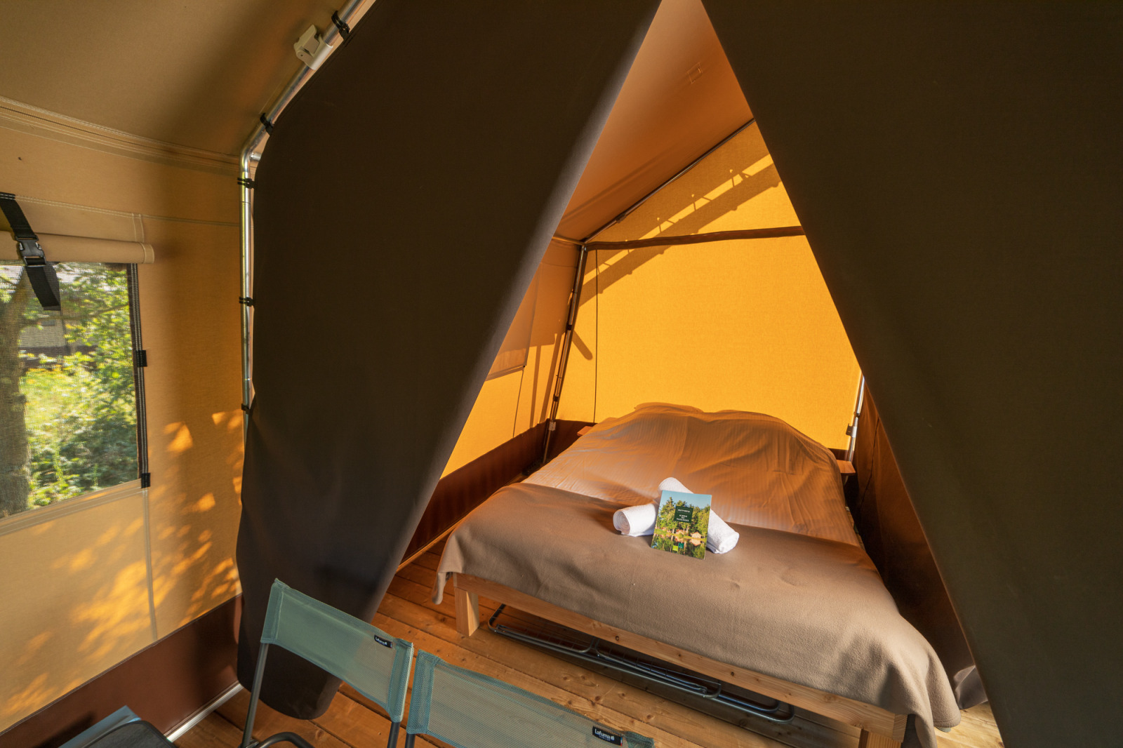 Binnenaanzicht van een Toile&bois tent Classic safaritent met bed bij Camping de Strasbourg, Frankrijk.