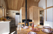 Interior de la cabaña Chalet Montana en Camping de Strasbourg, Francia, con mesa de comedor, cocina y estufa.
