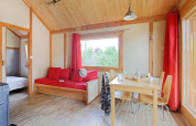 Luminoso y acogedor interior del Chalet Montana en Camping de Strasbourg, Francia, con madera y detalles rojos.
