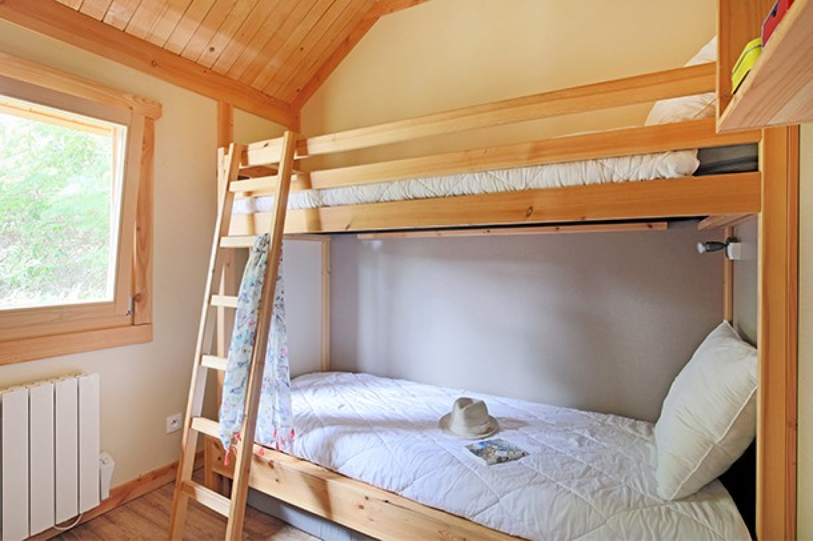 Slaapkamer met houten stapelbedden in Chalet Montana bij Camping de Strasbourg, Frankrijk. Licht interieur.