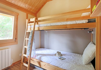 Chambre de chalet avec lits superposés en bois au Chalet Montana, Camping de Strasbourg, France. Lumineuse.