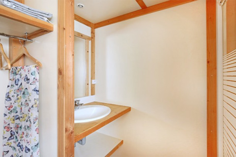 Baño moderno en el Chalet Montana en Camping de Strasbourg, Francia, con detalles de madera y espejo.