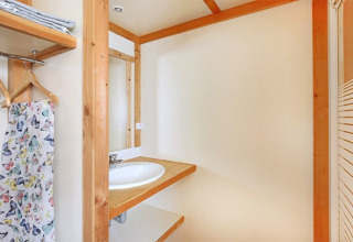 Baño moderno en el Chalet Montana en Camping de Strasbourg, Francia, con detalles de madera y espejo.