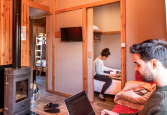 Couple travaillant sur des ordinateurs portables dans un chalet en bois, Chalet Montana au Camping de Strasbourg.