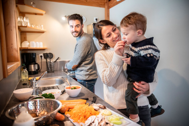 Familie kocht zusammen in der Küche des Chalet Montana auf dem Camping de Strasbourg in Frankreich.