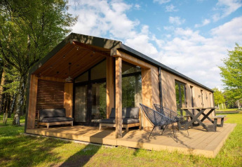 Cabaña moderna en la naturaleza en Wilsumer Berge, Alemania, con terraza y muebles al aire libre.