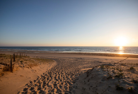 Atardecer sobre una tranquila playa de arena cerca de Saint-Michel-Escalus, Nueva Aquitania, Francia.