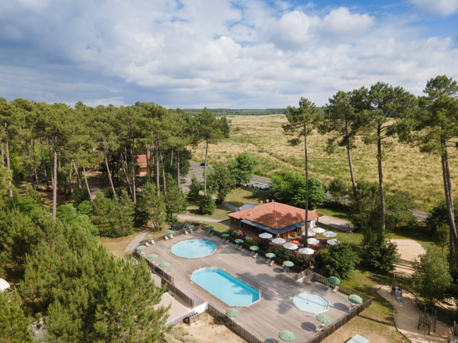 Huttopia Landes Sud holiday park in Nouvelle-Aquitaine, France, featuring pools, trees, and a terrace café.