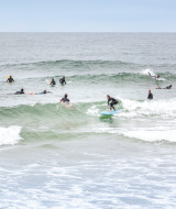 Surfistas montando olas cerca de Saint-Michel-Escalus, Nouvelle-Aquitaine, Francia, durante un día nublado.