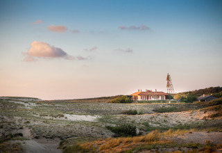 Una casa tra dune sabbiose al tramonto vicino a Saint-Michel-Escalus, Nouvelle-Aquitaine, Francia.