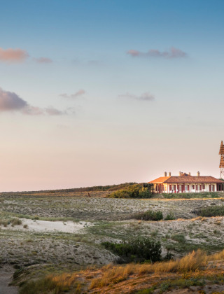 Casa entre dunas de arena al atardecer cerca de Saint-Michel-Escalus en Nouvelle-Aquitaine, Francia.