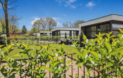 Moderne ferieboliger med grønne haver og blå himmel i Uniq Leisure feriepark, Gelderland, Holland.
