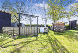 Udendørs område i Uniq Leisure feriepark, Gelderland, Holland, med indhegning, skilt og lille bar.