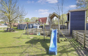 Parque infantil con tobogán, columpios y cabañas de madera en Uniq Leisure, Gelderland, Países Bajos.