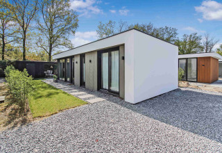 Et moderne feriehus med store vinduer og minimalistisk design i Uniq Leisure feriepark, Gelderland, Holland.