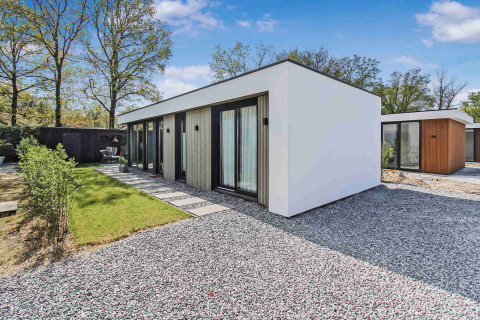 Et moderne feriehus med store vinduer og minimalistisk design i Uniq Leisure feriepark, Gelderland, Holland.
