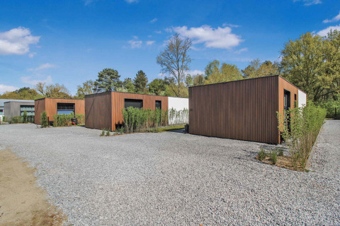 Cabañas modernas de madera en un área de grava en Uniq Leisure, parque vacacional en Gelderland, Países Bajos.