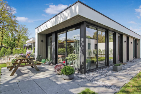Casa vacacional moderna con grandes ventanales, terraza y jardín en Uniq Leisure, Gelderland, Países Bajos.
