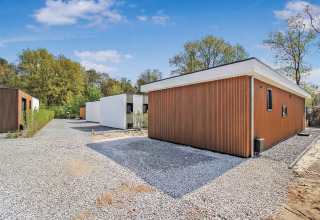 Moderne ferieboliger med træpaneler og grusveje i Uniq Leisure feriepark, Gelderland, Holland.