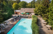 Billede af en udendørs pool omgivet af træterrasse og solsenge ved Huttopia Rambouillet i Île-de-France, Frankrig.