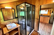Baño moderno con ducha acristalada en tienda glamping de Per Amore del Vino, Italia, decorado en madera.
