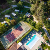 Aerial view of Huttopia Sarlat holiday park in Nouvelle-Aquitaine, France, featuring a pool and tennis court.