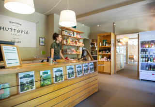 Receptionen på Huttopia Sarlat feriepark i Nouvelle-Aquitaine, Frankrig, med personale og butik.