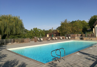 Udendørs swimmingpool ved Huttopia Sarlat feriested i Nouvelle-Aquitaine, Frankrig, omgivet af natur.