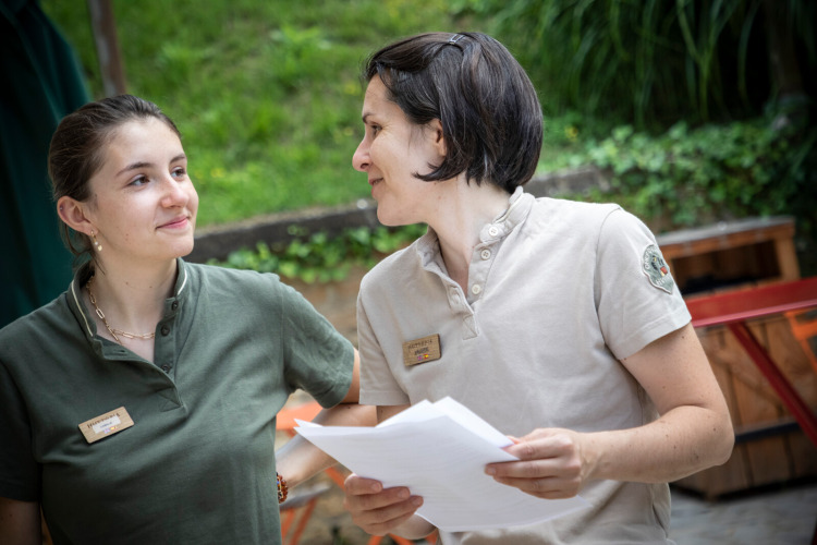 Two female staff members chatting at Huttopia Sarlat holiday park in Nouvelle-Aquitaine, France.