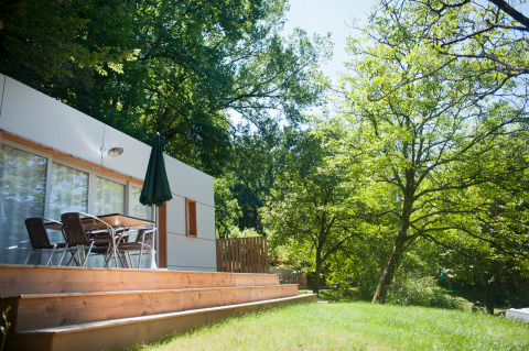Mobile Home Vancouver im Huttopia Sarlat, Frankreich, mit Terrasse, Tisch, Stühlen und grüner Natur
