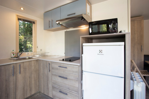 Coin cuisine moderne dans un mobile home Vancouver à Huttopia Sarlat en France, avec réfrigérateur Electrolux.