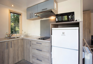 Coin cuisine moderne dans un mobile home Vancouver à Huttopia Sarlat en France, avec réfrigérateur Electrolux.