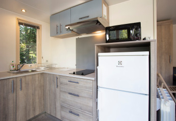 Moderne tekøkken i en Mobile home Vancouver-hytte på Huttopia Sarlat i Frankrig med træskabe.