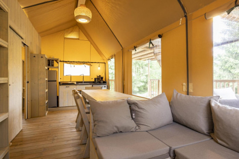 Innenraum des Safari-Zelts Ranger Lodge bei Arden Parks in Signy l'Abbaye, Frankreich, mit Holzmöbeln.